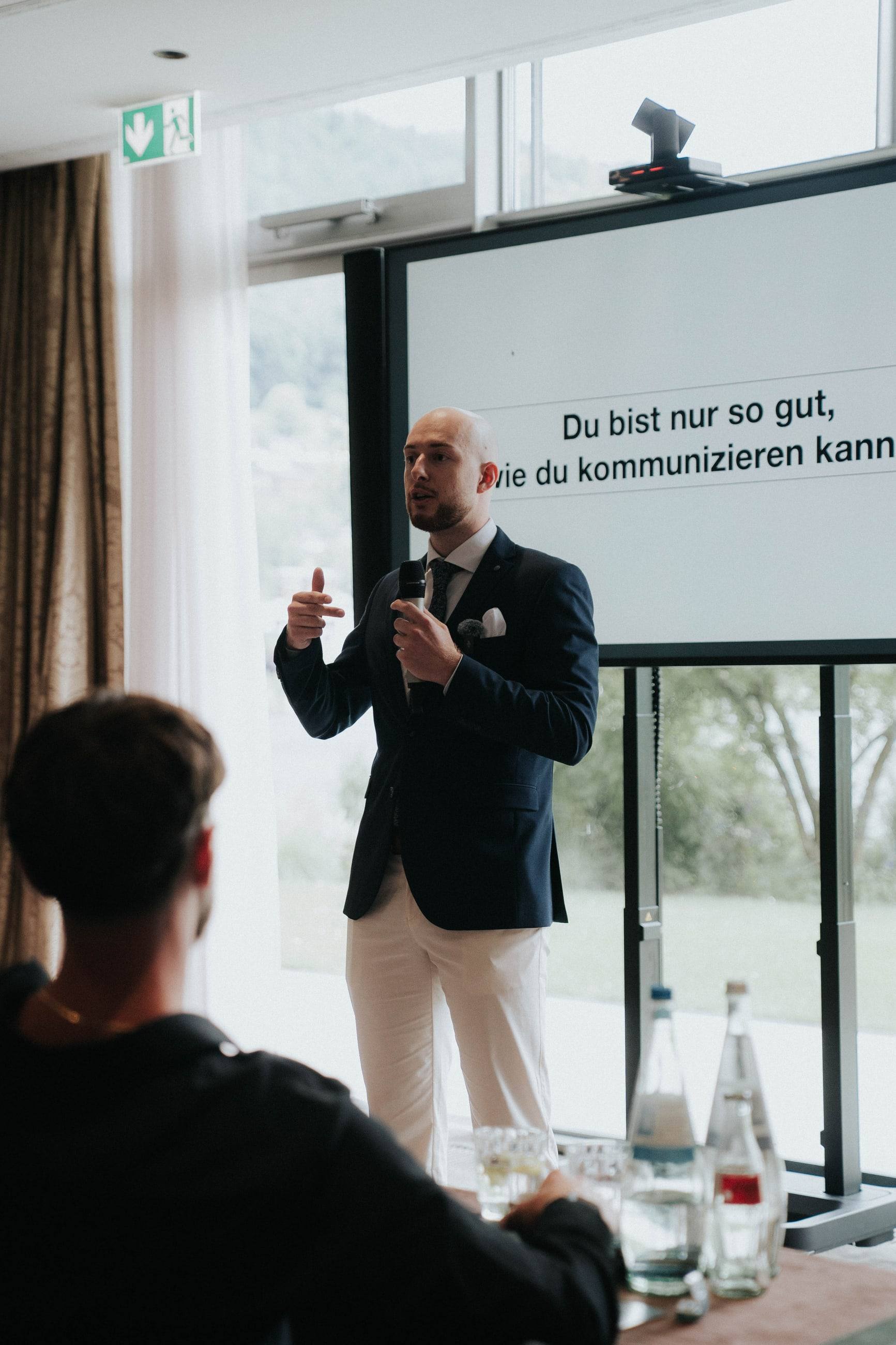 Tim Marco hält am Tegernsee eine Keynote vor der Folie „Du bist nur so gut, wie du kommunizieren kannst“